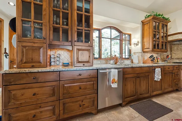 a kitchen with a sink window and cabinets