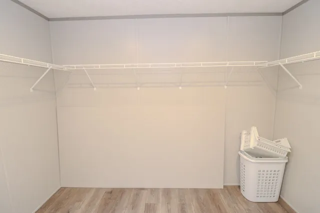 a view of a room with wooden floor and a window