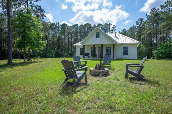 a view of a house with a yard chairs and a table and chairs