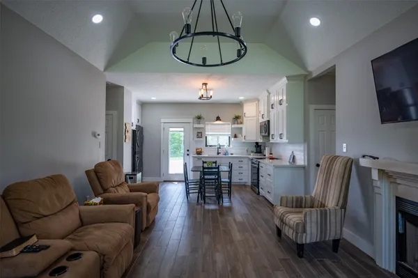 a living room with furniture a dining table and a chandelier