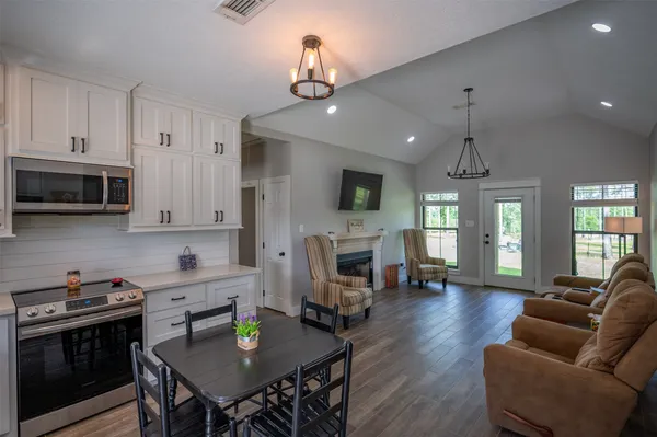 a kitchen with sink refrigerator stove dining table and chairs