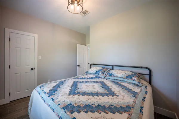 a bed sitting in a bedroom next to a window with wooden floor