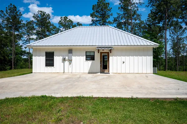 a house with green field in front of it