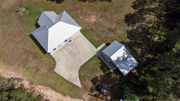 an aerial view of a house with a yard and large trees