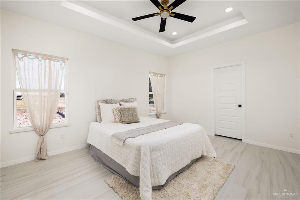 1602 Foxtail Street Donna, TX 78537 - Photo 7 of 16 a bedroom with a bed and a chandelier