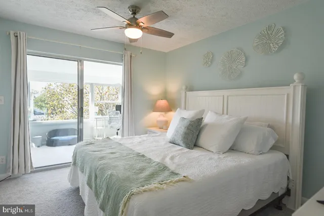 a bedroom with a bed and a flat tv screen on dresser