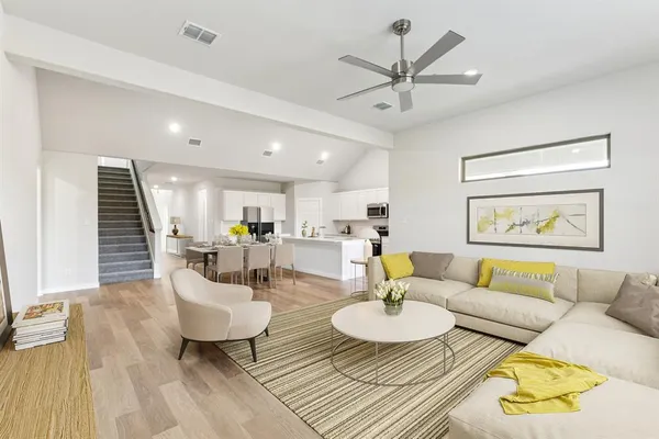 a living room with furniture and a wooden floor