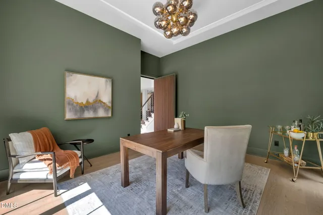 a kitchen with kitchen island granite countertop a stove a sink a dining table and chairs with wooden floor