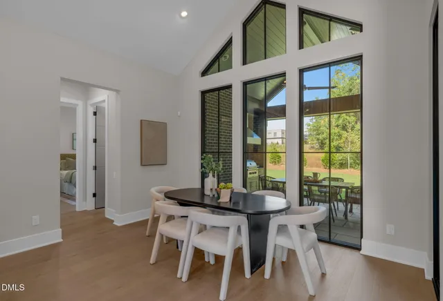 a kitchen with stainless steel appliances granite countertop a table chairs in it and wooden floors