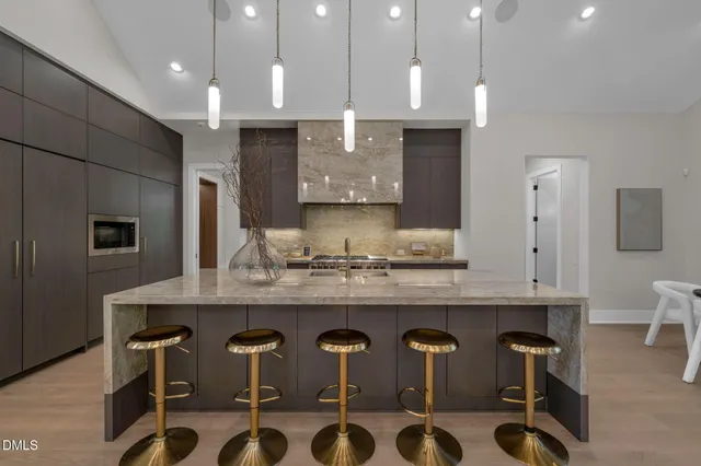a kitchen with stainless steel appliances granite countertop a refrigerator a stove and a sink