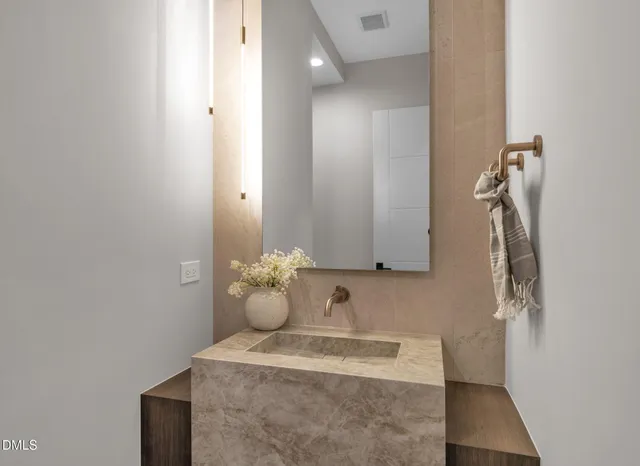 a bathroom with a sink mirror and shower