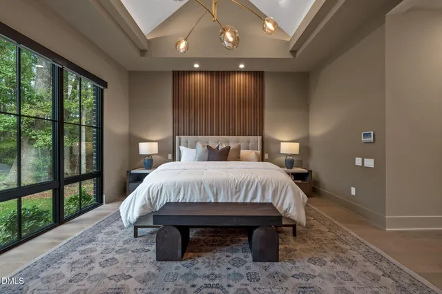 a bedroom with a large bed and a painting on the wall