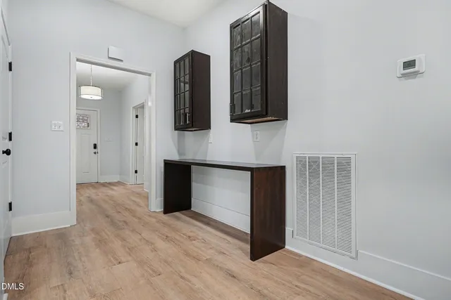 a view of front door and entryway with wooden floor