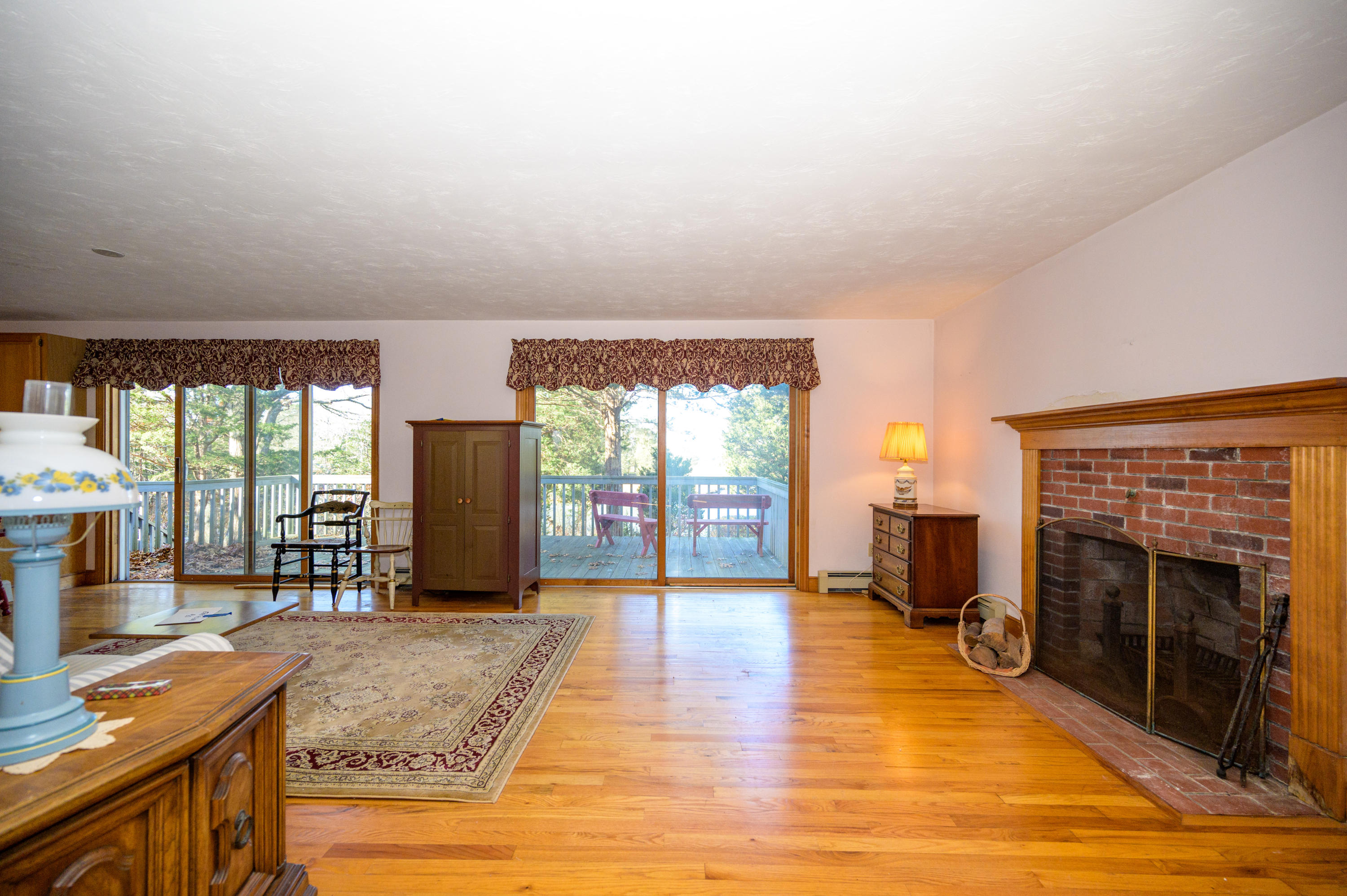 18 Warren Road Bourne, MA 02532 - Photo 18 of 36 a living room with furniture a fireplace and a floor to ceiling window