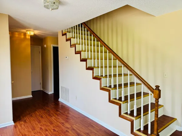 a view of staircase with wooden floor and front door