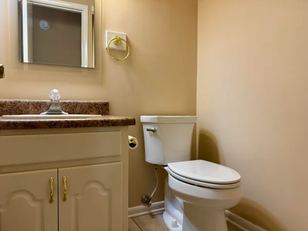 a bathroom with a granite countertop toilet and a sink