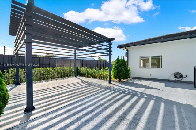 a view of backyard with plants and wooden fence