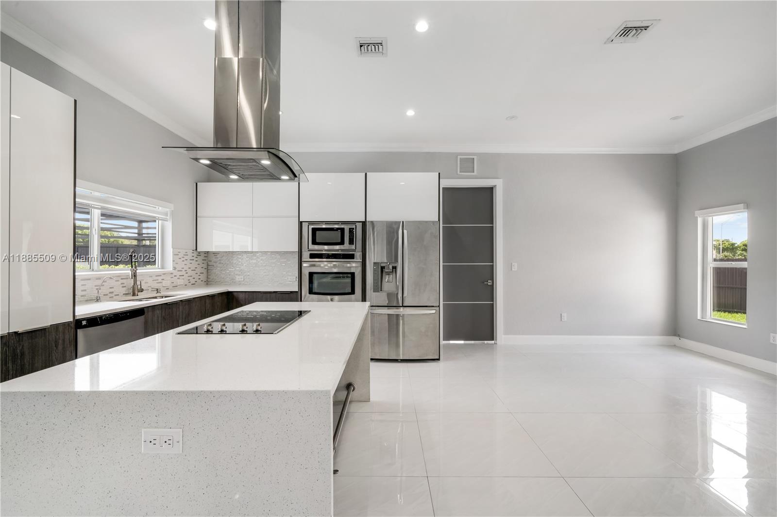 11921 Southwest 82nd Road Miami, FL 33156 - Photo 40 of 42 a kitchen with stainless steel appliances a stove a refrigerator a sink and white cabinets with wooden floor