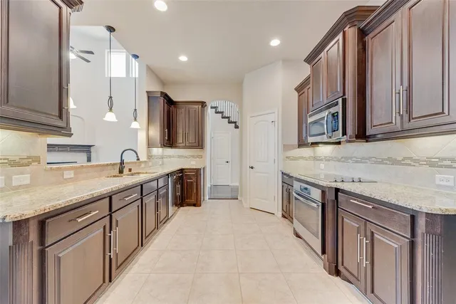 a large kitchen with stainless steel appliances granite countertop a sink and cabinets