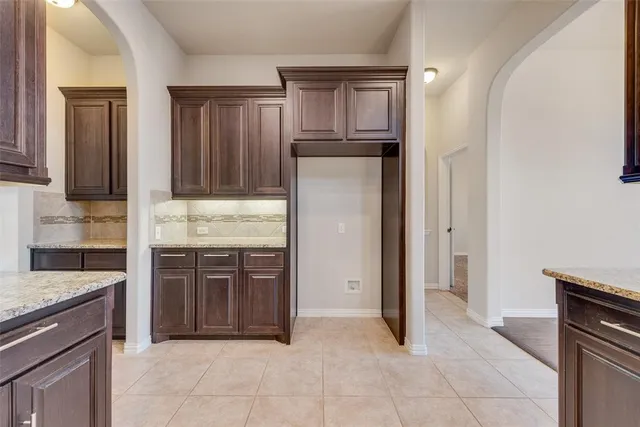 a kitchen with kitchen island granite countertop cabinets and refrigerator