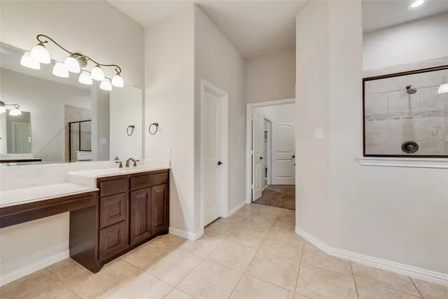 a spacious bathroom with a granite countertop sink a mirror and a shower