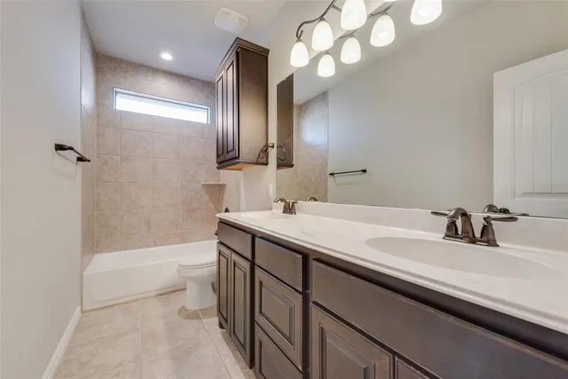 a bathroom with a sink a toilet and a large mirror