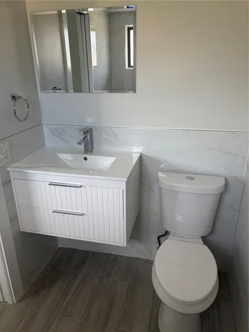 a bathroom with a toilet sink and mirror
