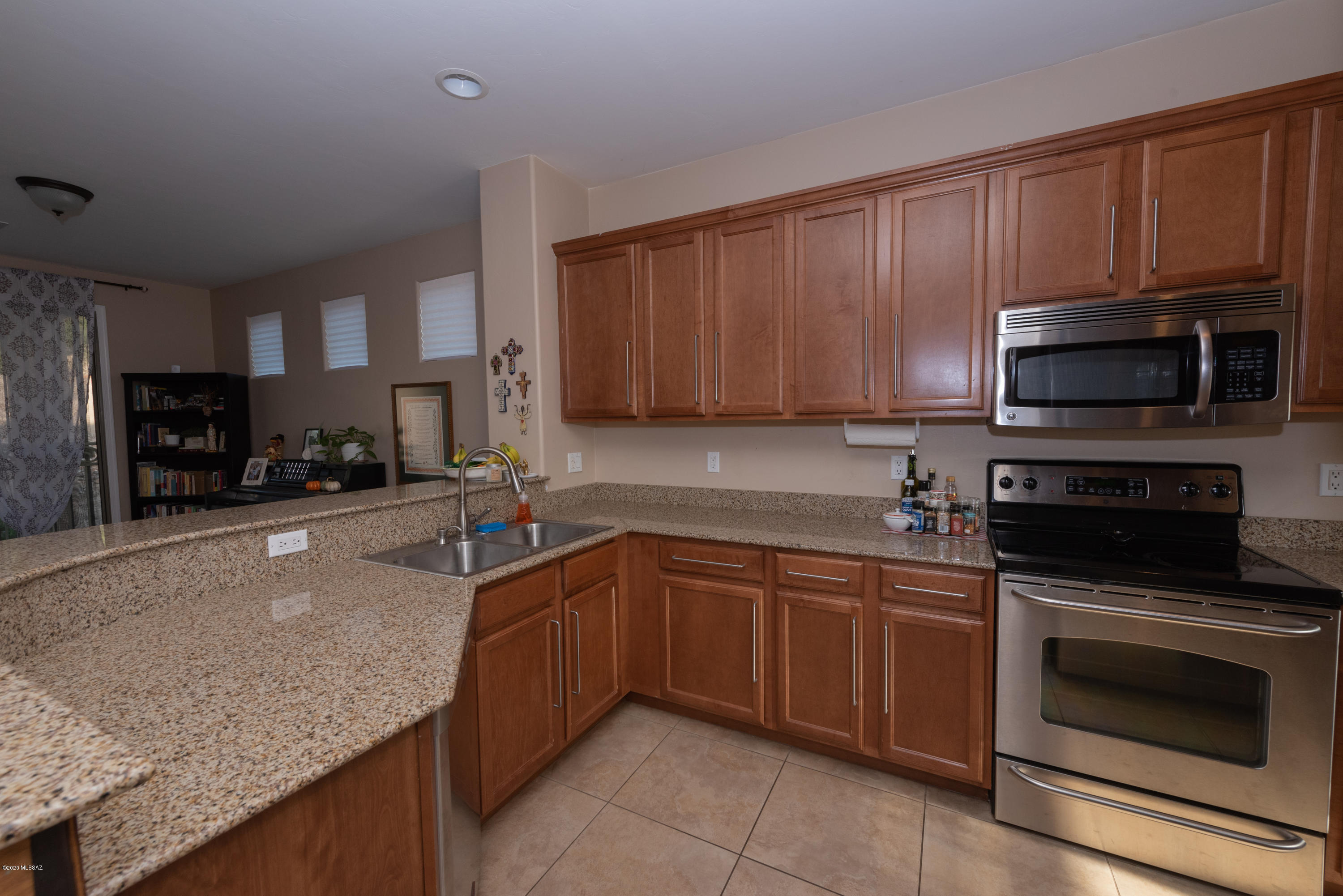 12910 Bloomington Loop Oro Valley, AZ 85755 - Photo 7 of 30 a kitchen with stainless steel appliances granite countertop wooden cabinets a stove a sink and a microwave
