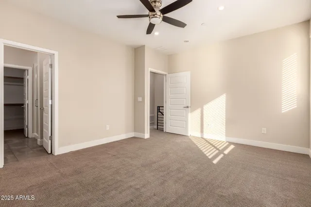 an empty room with closet and ceiling fan