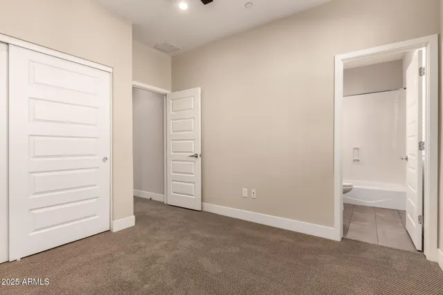 an empty room with closet and a bathroom