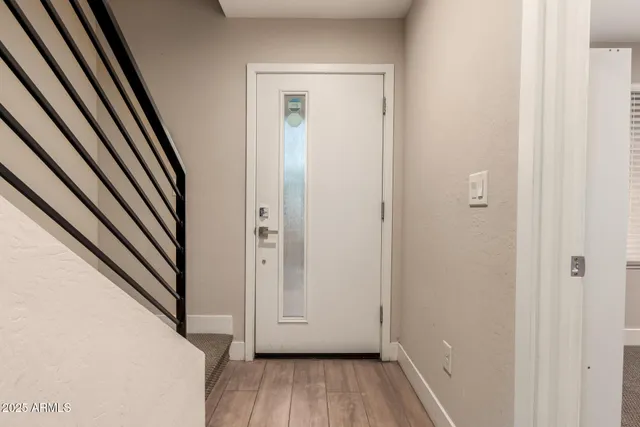 a view of a hallway with wooden floor and staircase