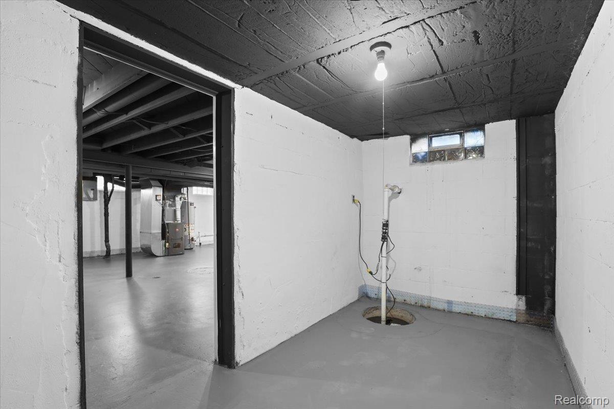 43600 Crowley Road Belleville, MI 48111 - Photo 26 of 33 Unfinished basement with painted concrete walls, exposed ceiling joists, concrete flooring, and a glass block window