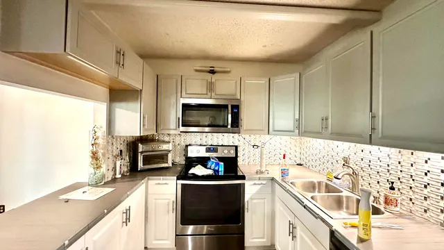 a kitchen with a sink a stove and cabinets