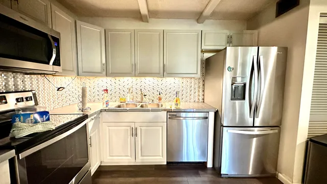 a kitchen with stainless steel appliances a refrigerator sink and microwave