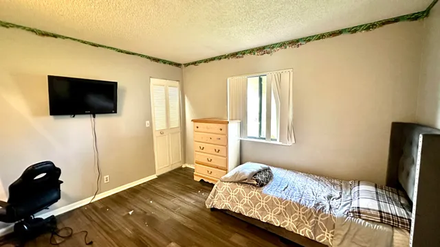 a bedroom with a bed and a flat screen tv