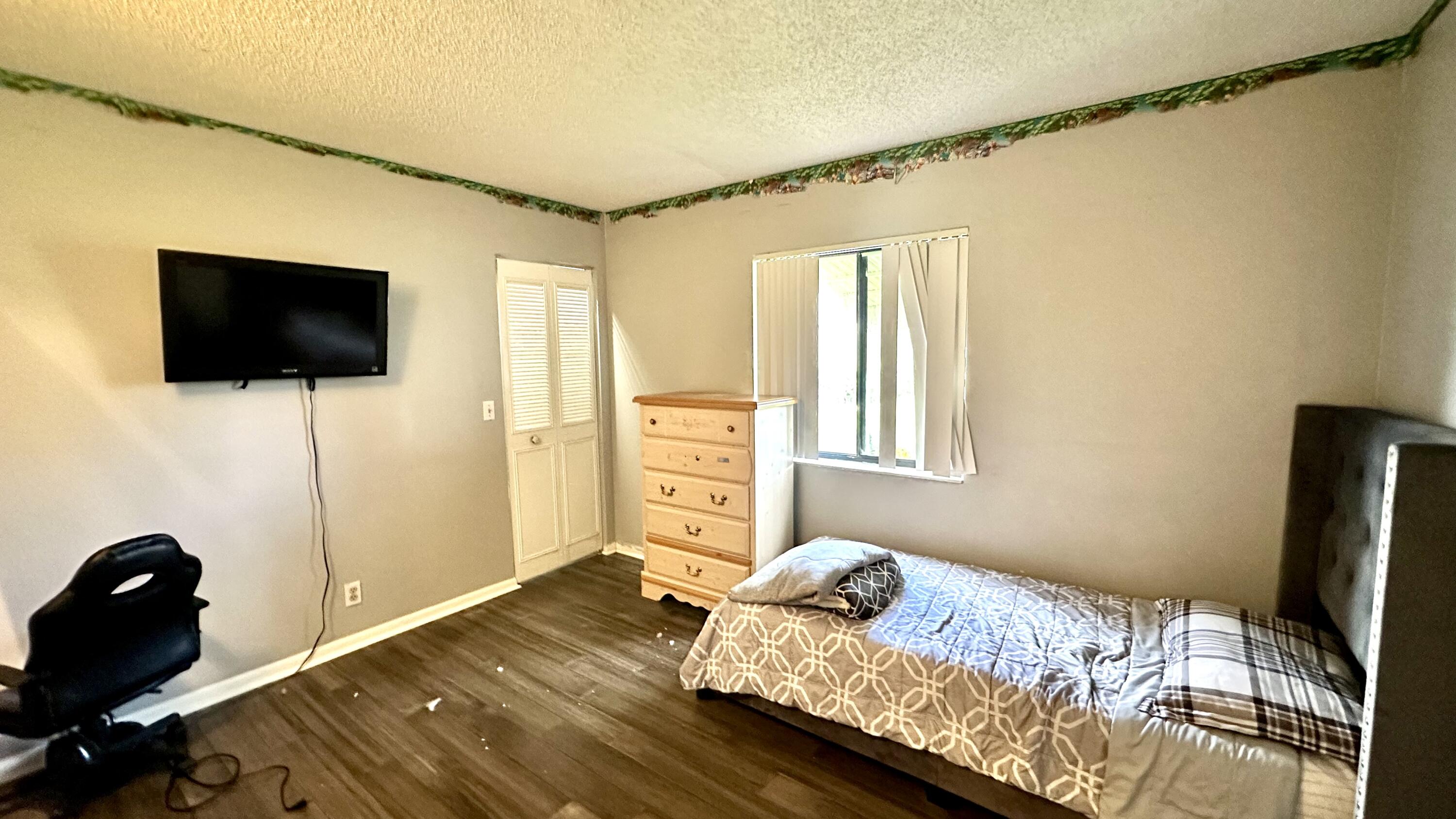 533 Shady Pine Way, Unit B1 Greenacres, FL 33415 - Photo 8 of 19 a bedroom with a bed and a flat screen tv