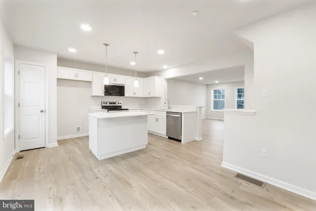 a view of kitchen with granite countertop cabinets and refrigerator