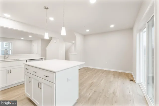 a kitchen with a sink wooden floor and white cabinets