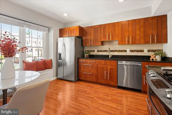 a living room with stainless steel appliances furniture a refrigerator and a table