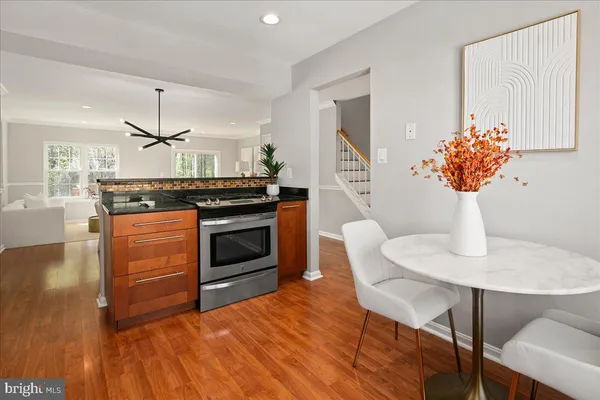 a kitchen with stainless steel appliances wooden floor sink and wooden cabinets