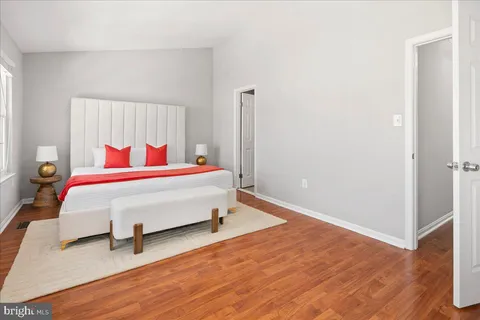 a bedroom with a bed and wooden floor