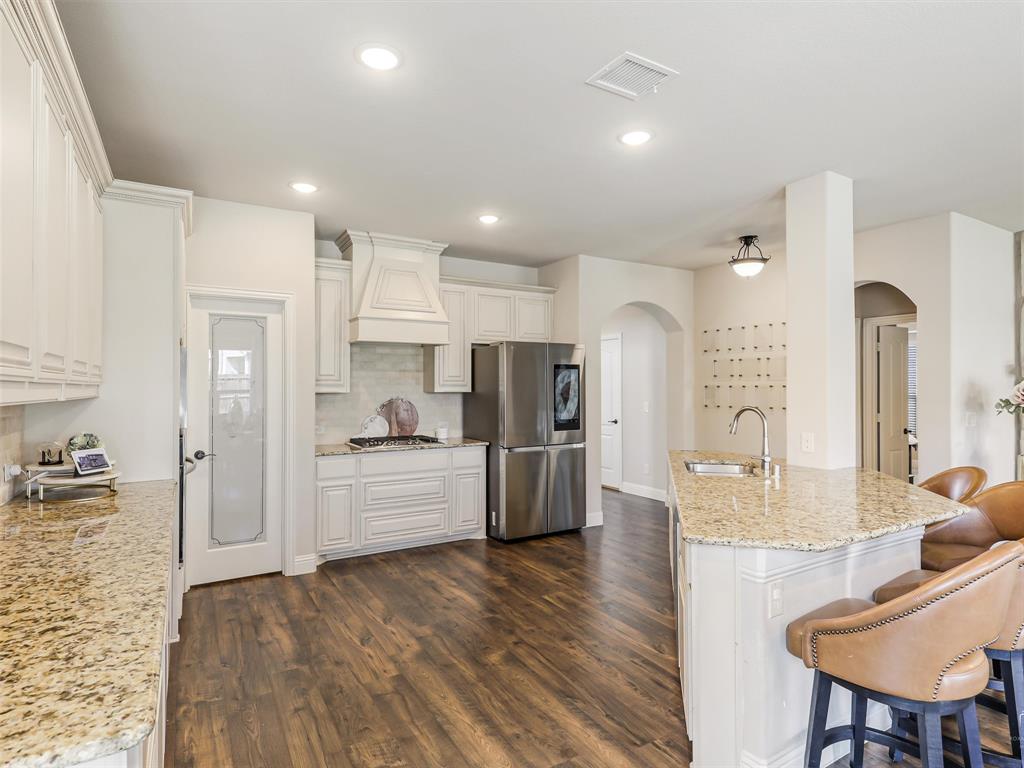 1216 Tree Shadow Lane Anna, TX 75409 - Photo 15 of 37 a large kitchen with kitchen island a large counter top space a sink stainless steel appliances and cabinets