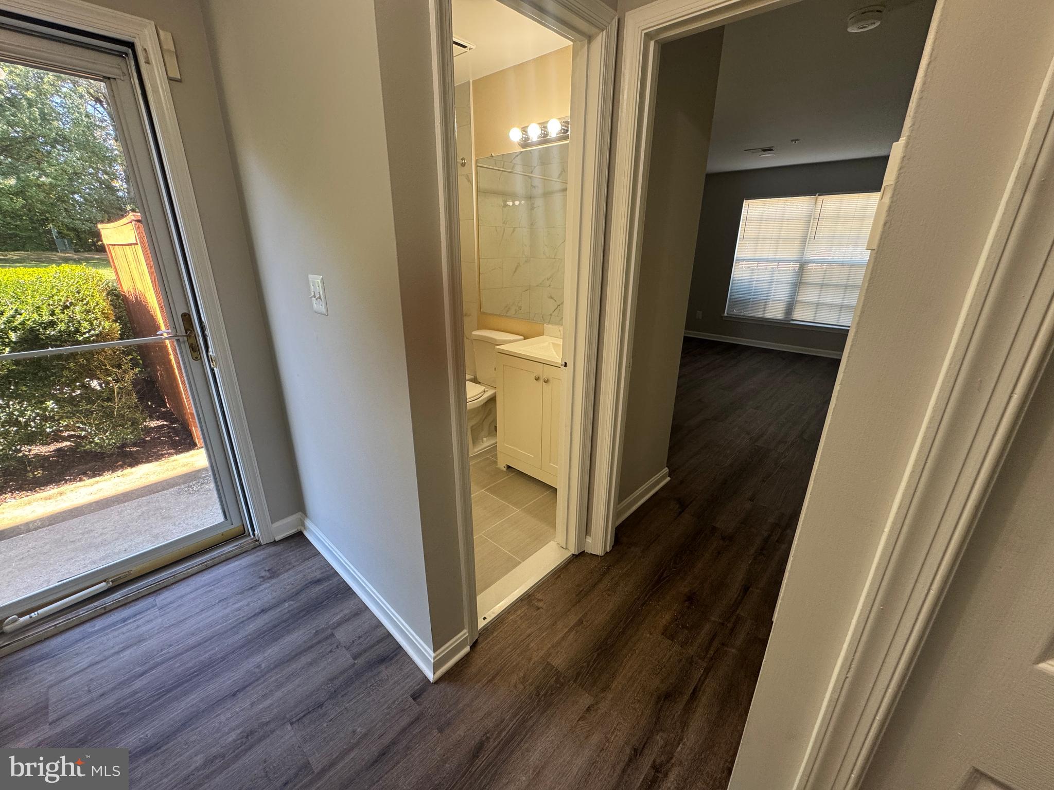 11263 Raging Brook Drive, Unit 253 Bowie, MD 20720 - Photo 2 of 22 a view of a hallway with wooden floor and glass door