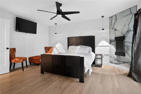 a bedroom with a bed and a flat tv screen on wall