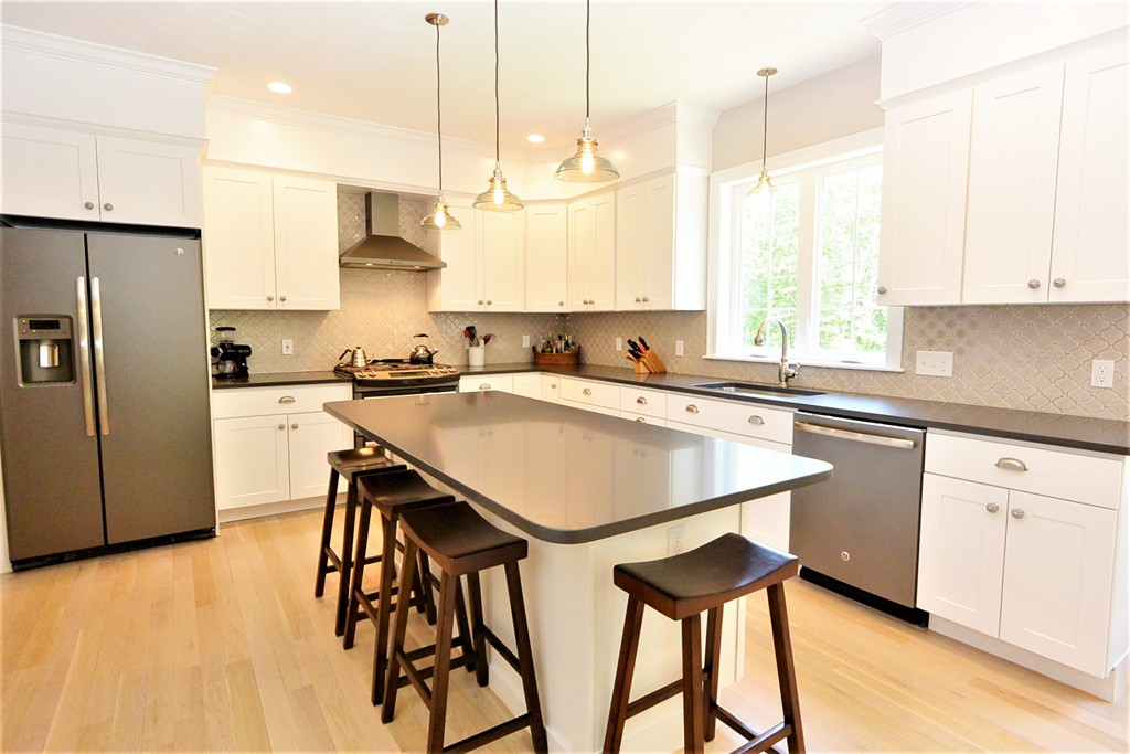 424 Langen Road Lancaster, MA 01523 - Photo 2 of 25 a kitchen with stainless steel appliances kitchen island a table chairs sink and cabinets