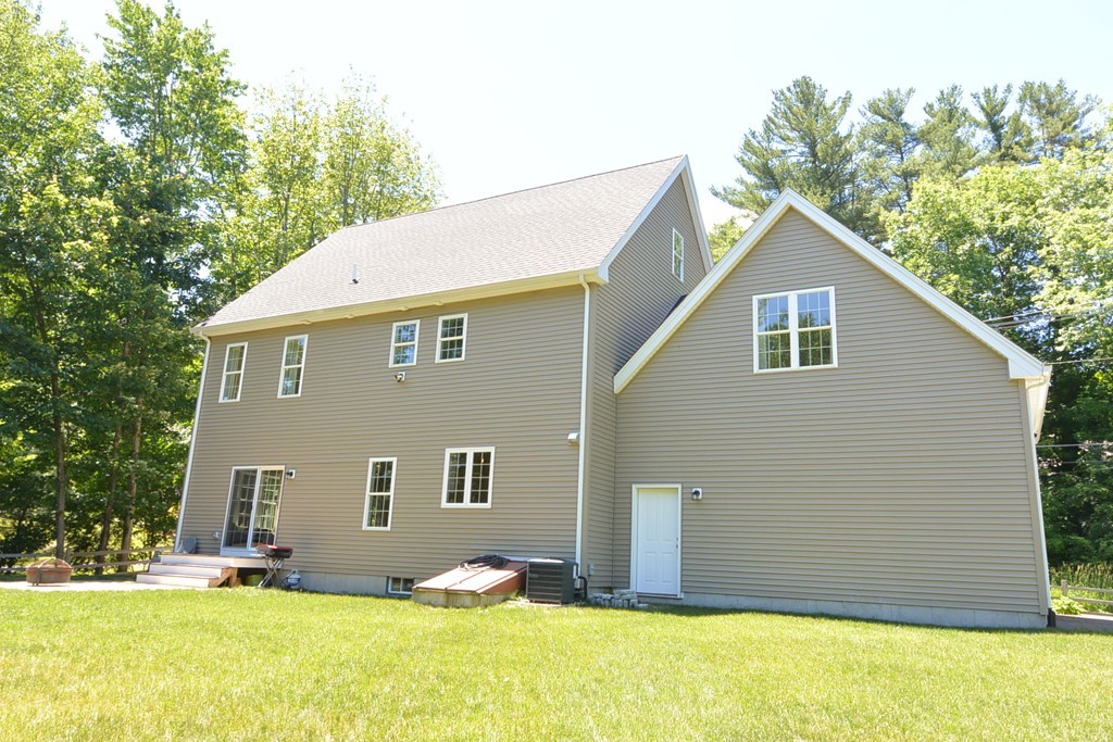 424 Langen Road Lancaster, MA 01523 - Photo 22 of 25 a front view of house with yard and trees in the background