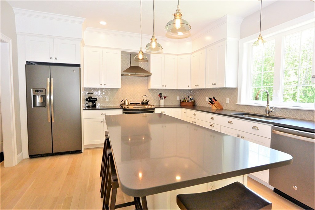424 Langen Road Lancaster, MA 01523 - Photo 4 of 25 a kitchen with stainless steel appliances a refrigerator a sink a stove and white cabinets