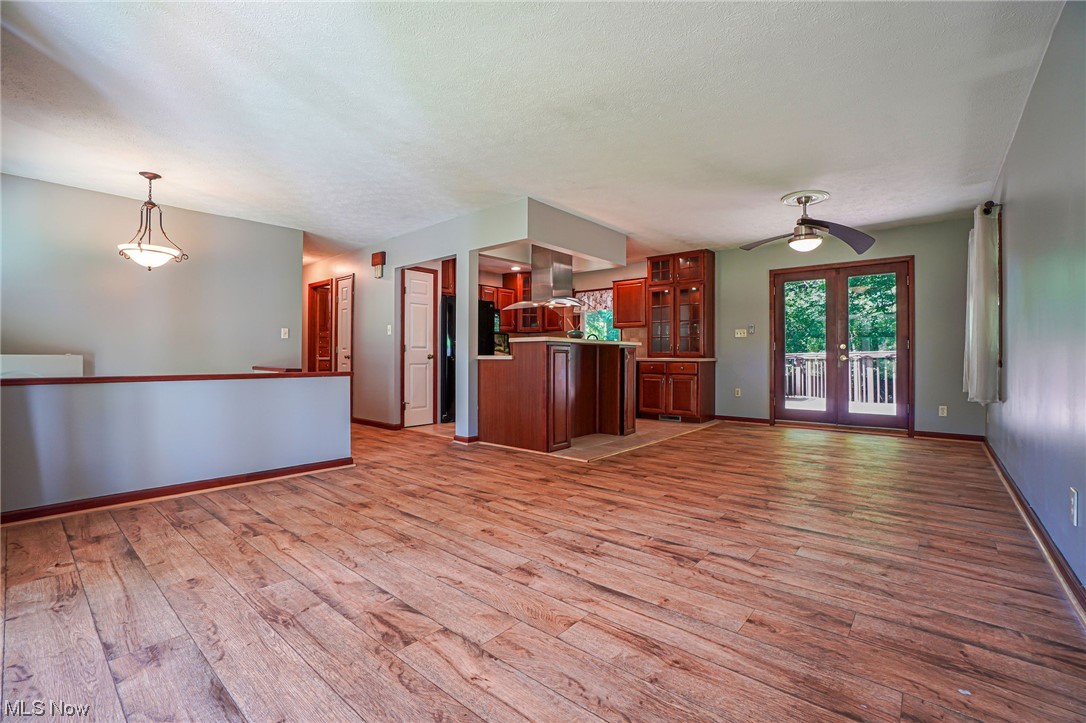 6406 Liberty Road Solon, OH 44139 - Photo 32 of 35 Kitchen featuring hanging light fixtures, dark brown cabinets, light hardwood floors, stainless steel fridge, ceiling fan, and range hood