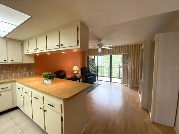 a kitchen with granite countertop a stove a sink dishwasher and a refrigerator with wooden floor