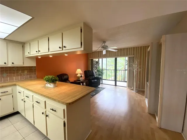 a kitchen with granite countertop a stove a sink dishwasher and a refrigerator with wooden floor